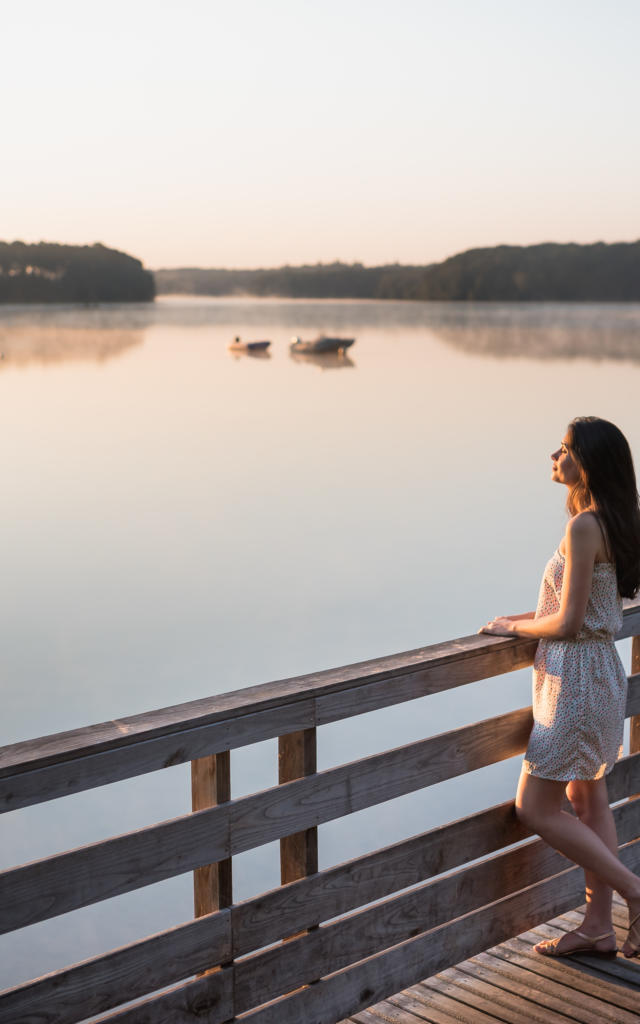 Une jeune femme au lever du soleil sur le lac de Trémelin