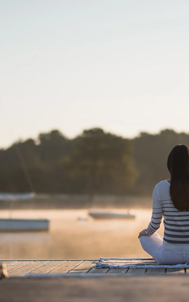 Une jeune femme au lever du soleil sur le lac de Trémelin