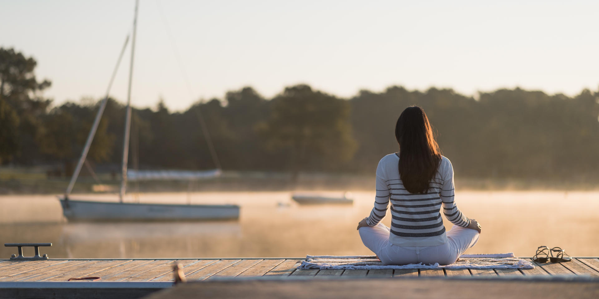 Une jeune femme au lever du soleil sur le lac de Trémelin