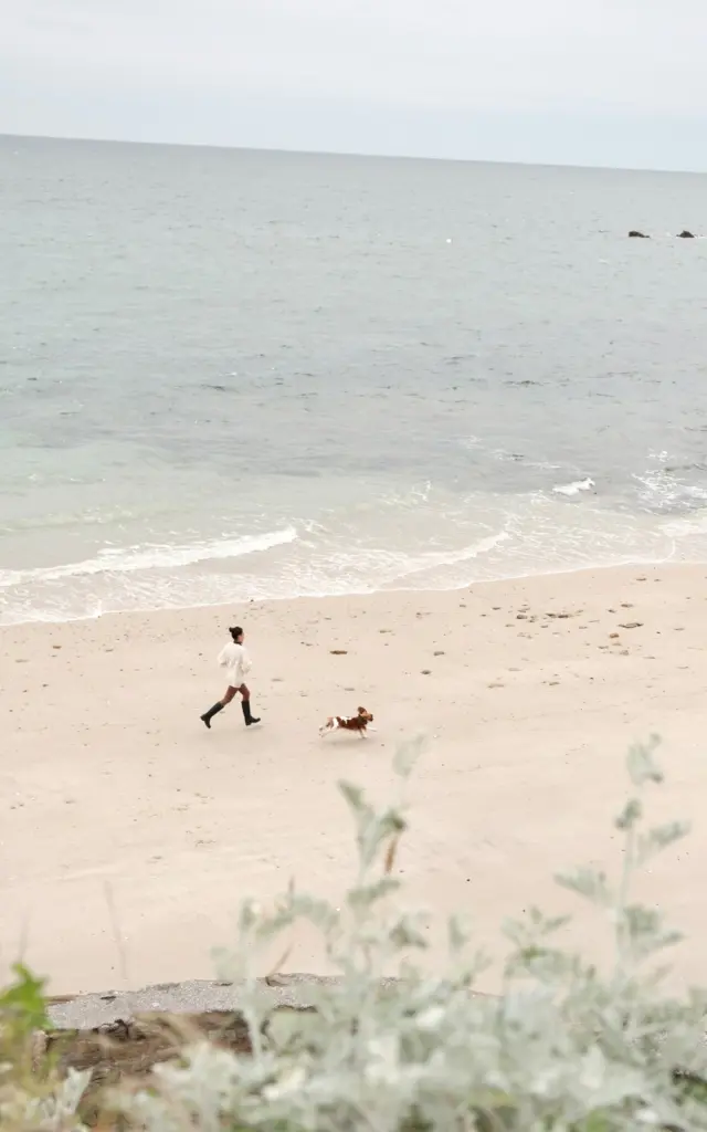 Quiberon - Femme qui court avec son chien sur la plage du Chat Botté