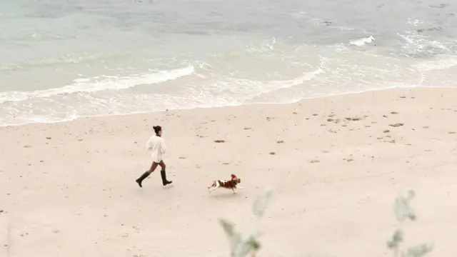 Quiberon - Femme qui court avec son chien sur la plage du Chat Botté